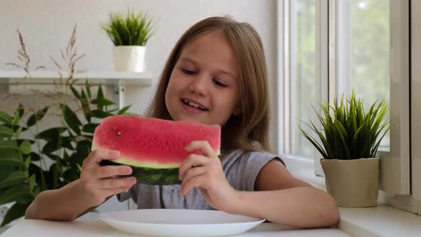 Happy Cute Little Girl Eating Fresh Juicy Watermelon at Home