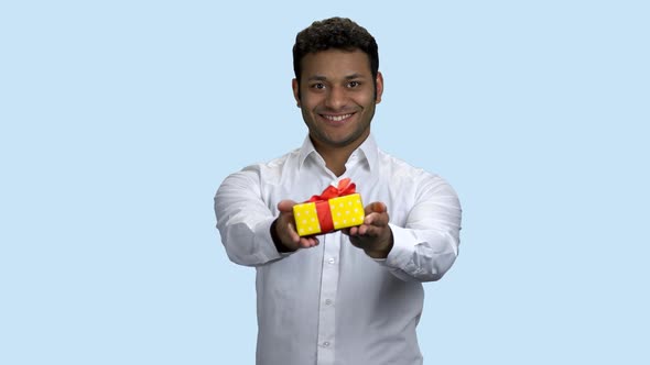 Smiling Indian Man Handing Gift Box.