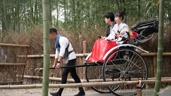 Tourists Enjoying a Rickshaw Ride at Arashiyama Bamboo Forest in Kyoto Japan