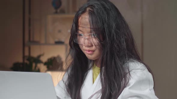 Young Asian Scientist Girl With Dirty Face Using Lap Top Computer In Laboratory