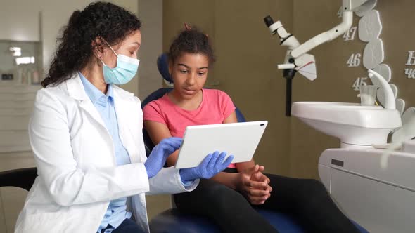 Woman Dentist Showing Dental Xray to Kid Patient