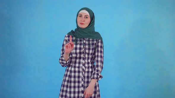 Young Muslim Woman Expresses Disapproval on Blue Background