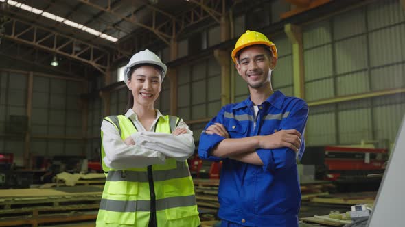 Portrait of Asian male and female industrial worker working in factory.