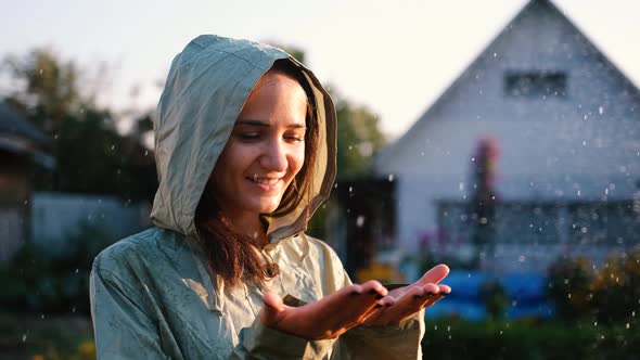 Happy Young Woman in Green Raincoat Near Her Country House Enjoying a Calm Rainy Day Breathing Fresh