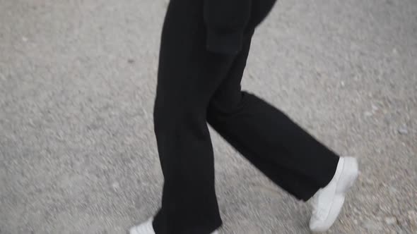 Young Blonde Woman in Black Clothes and Face Mask Walking in Urban Exterior. New Normal and Virus Pr