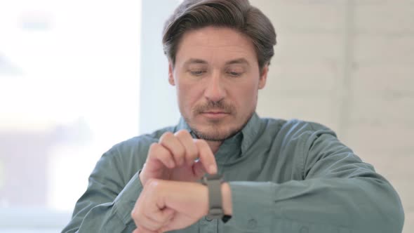 Middle Aged Man using Smart watch 