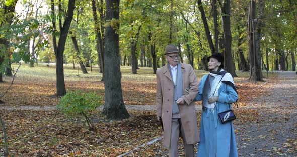 Happy Elegant Retired Family Couple Walking and Having Pleasant Talk in Autumn