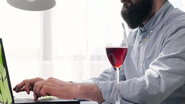 Bearded Man That Works at the Computer Full of Reminder Notes Drink Wine