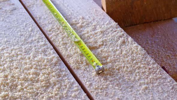 Measuring yellow tape measure scale with centimeters on wooden boards for marking the place of cutti