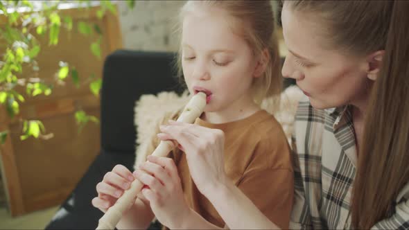 Mom Teaches Her Daughter How to Hold the Flute