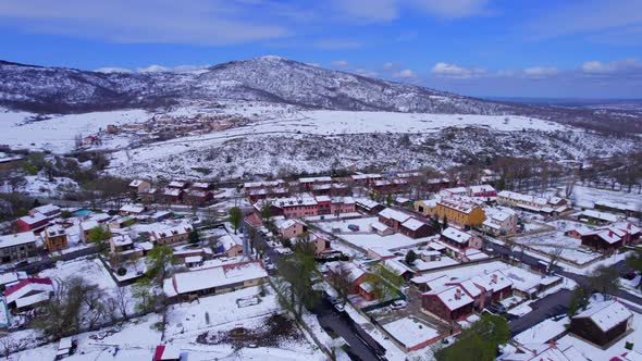 Pull out aerial view over the snow-covered countryside of Pradera de Navalhorno in Spain