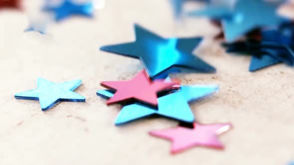 Star shape decorations falling on wooden table