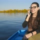 The Girl is Talking on the Phone While Sitting in a Boat on the Water - VideoHive Item for Sale