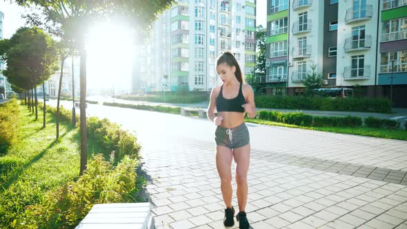 Female Runner Tying Shoelaces on Bench.