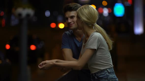Happy Young Couple in Love Talking and Hugging on City Street at Night, Romance