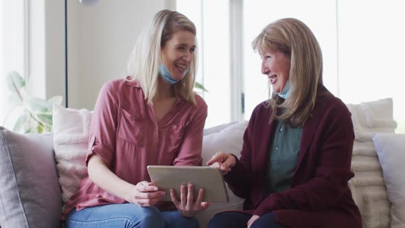 Mother and daughter using digital tablet at home