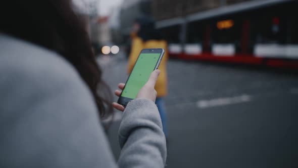 Girl Using Green Screen Mobile App on Touchscreen of Smartphone to Call Taxi or View Route