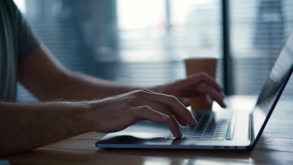 Man's Hands Typing on a Laptop Keyboard