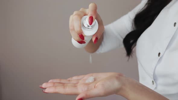 Close Up of Professional Beautician Shows How to Applying Body Lotion Cream on Hands