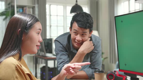 Female Works With Her Male Colleague On A Project On Her Personal Computer With Mock-Up Green Screen