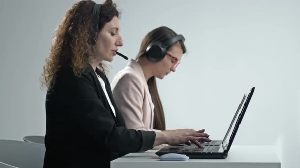 Customer Support Agent or Call Center with Headset Works on Desktop Computer While Supporting the