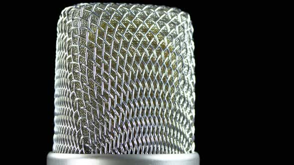 Studio Condenser Microphone Rotates on a Black Background