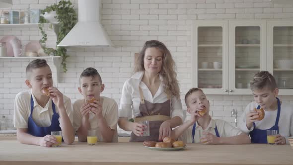 Portrait Attractive Happy Woman and Her Four Teen Son Eating Pies and Drinking Orange Juice in the