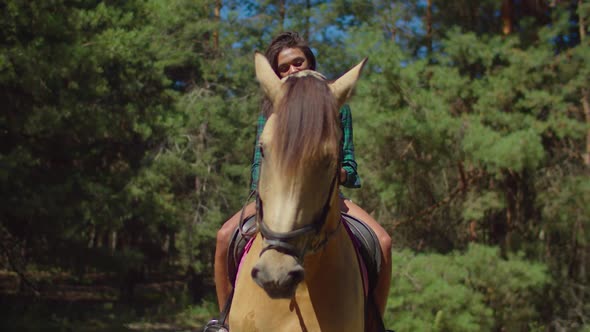 Pretty Female Sitting in Saddle on Purebred Horse