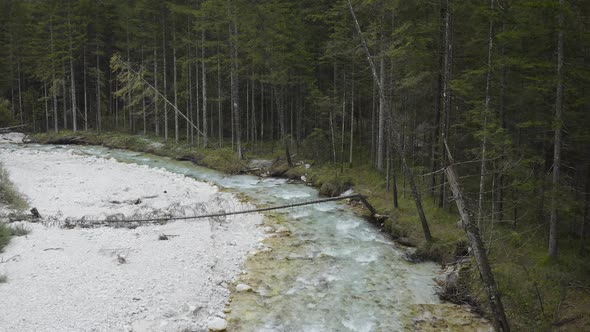 Aerial view of Fast Moving River with Rapids Surrounded by Forest