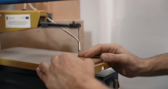 Woodworking at the Workshop Carpenter Uses Automatic Jigsaw and Cuts Small Plywood Parts