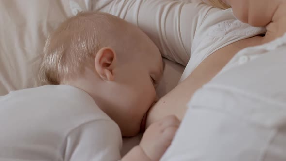 Closeup Adorable Toddler Sleeping and Drinking Milk From Mother Breast