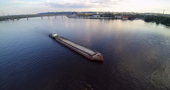 Long Barge with Sand on Industrial City River