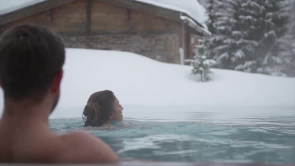 A man and woman couple playing in an outdoor a pool at a luxury spa resort