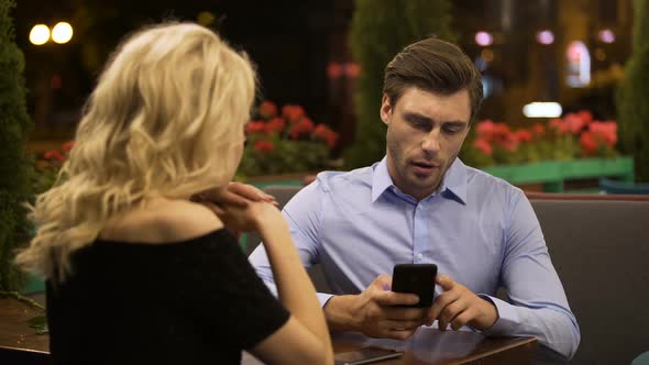 Woman Trying to Attract Attention of Her Boyfriend Who Actively Working on Phone