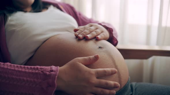 Happy Pregnant Woman and Expecting Baby at Home