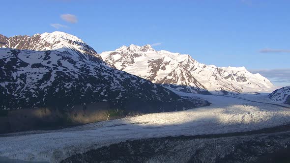 Aerial shot of glacier and lake with snowy mountains, Alaska