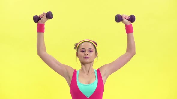 Retro Portrait Closeup of Young Woman in Colorful Sportswear Lifting Weights While Doing Aerobics in