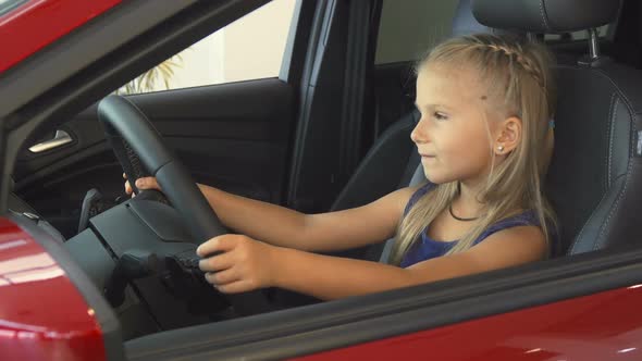 Baby Girl Sits at the Steering Wheel and Pretends To Drive