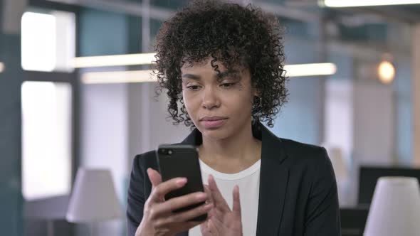 Portrait of Shocked African Businesswoman Reacting To Loss on Smartphone