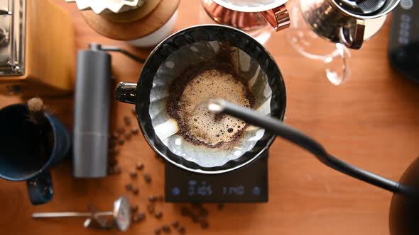 The barista is brewing coffee with traditional drip brewing equipment.