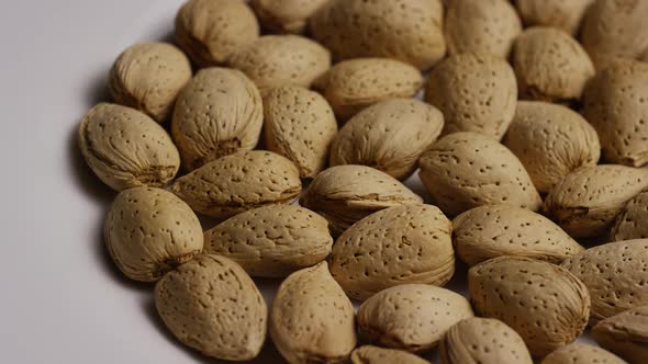 Cinematic, rotating shot of almonds on a white surface - ALMONDS