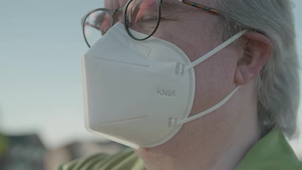 Close up of man wearing KN95 mask with glasses