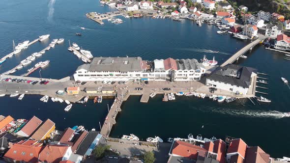 Aerial: sea side hill island city with port at Kragero, Norway - drone tilt up shot