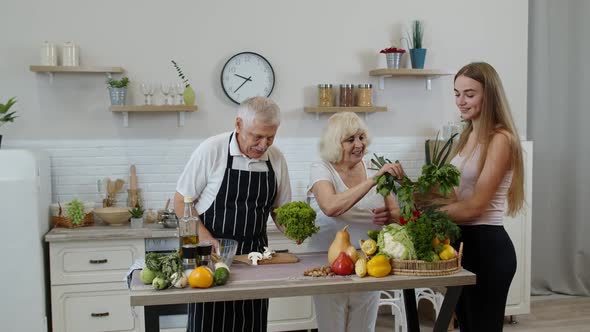 Elderly Couple in Kitchen Receiving Vegetables From Grandchild. Raw Food Healthy Eating Diet