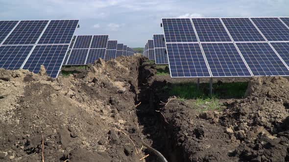 Laying Cable in the Trenches Between the Rows of Solar Panels Power Station