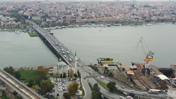 Aerial view of cars and busses crossing Ataturk Bridge over the Bosphorus River next to a mosque on