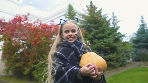 Cheerful Girl Shows Thumb Up, Holds Jack Pumpkin for Halloween, Autumn Holiday