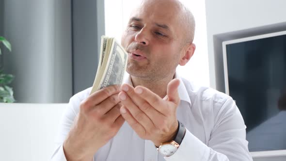 Young Successful Freelancer in the Office Holding a Winning Bundle of Dollars