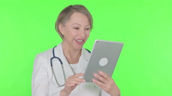 Video Call on Tablet By Old Female Doctor on Green Background