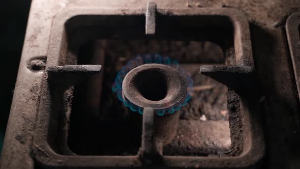 Gas Burns with a Blue Flame in an Old Gas Stove Burner in Terrible Living Conditions